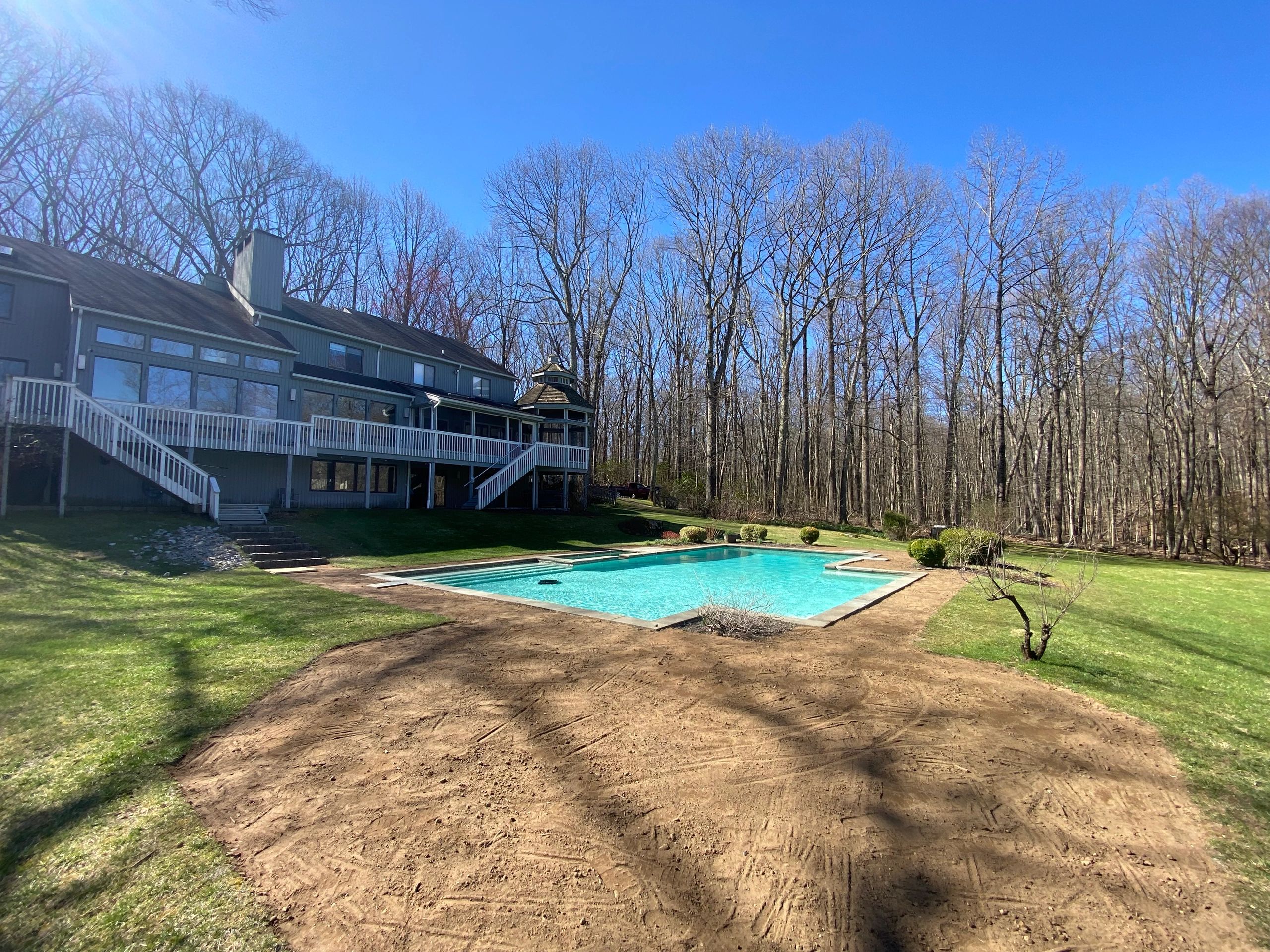 Before photo of bare soil prepared for sod installation around a pool in Fairfield County, CT
