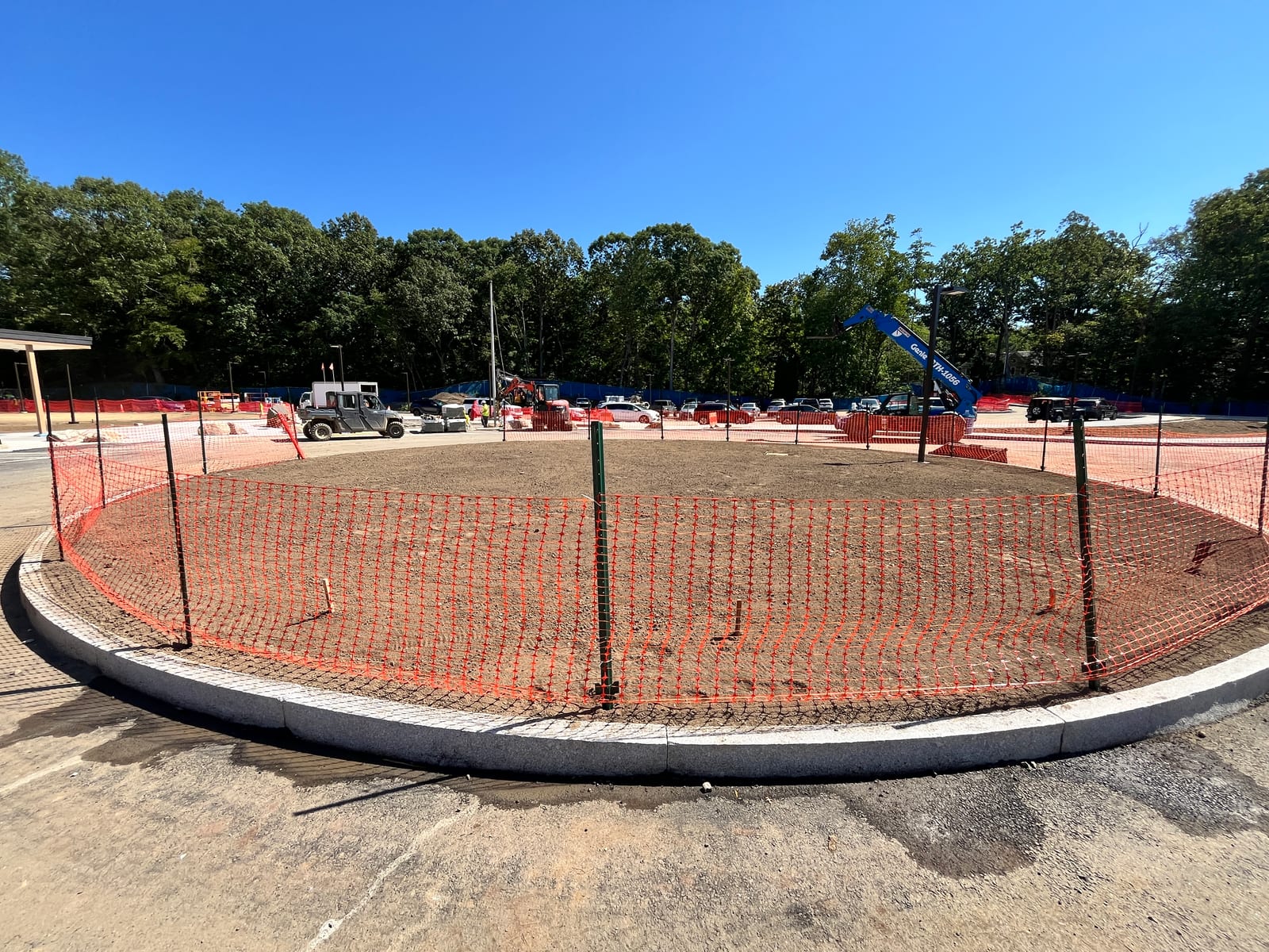 Wide pre-install view of the new Central Middle School grounds in Greenwich, CT with construction fencing, equipment, and graded lawn areas being prepared for sod