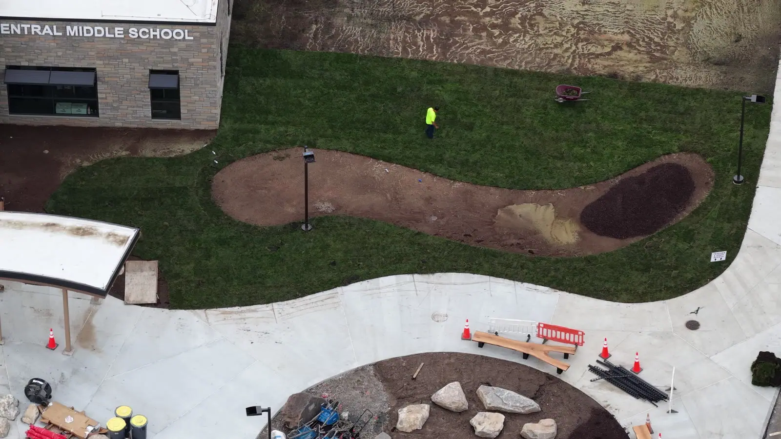 Short aerial pass over the finished building-side sod and curving landscape bed at Central Middle School in Greenwich
