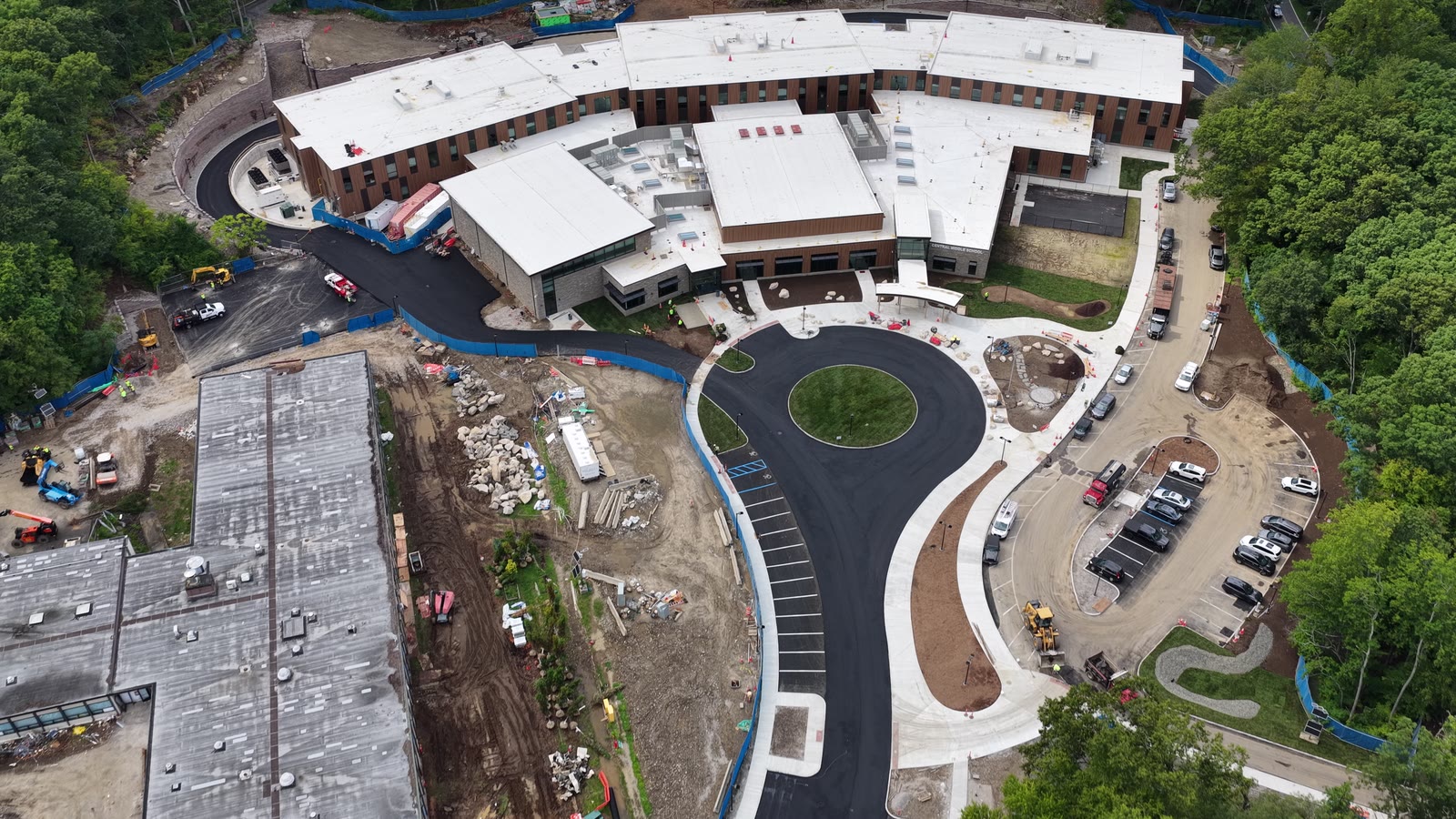 Completion-day campus flyover showing CT Sod's finished turf zones within the larger active construction site. Remaining open-soil areas belong to the project landscaper's separate hydroseed plan