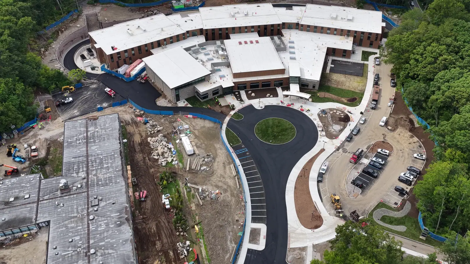 Completion-day campus flyover showing CT Sod's finished turf zones within the larger active construction site. Remaining open-soil areas belong to the project landscaper's separate hydroseed plan