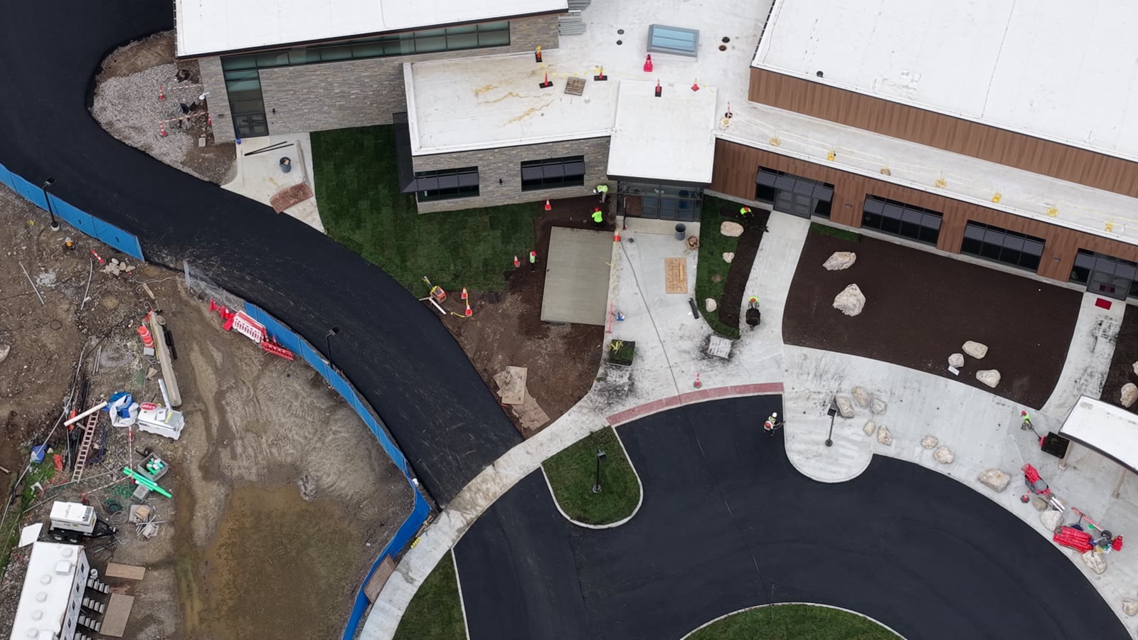 Completion-day flyover showing finished sod along the Central Middle School entrance building, circular drive, and curved walkways