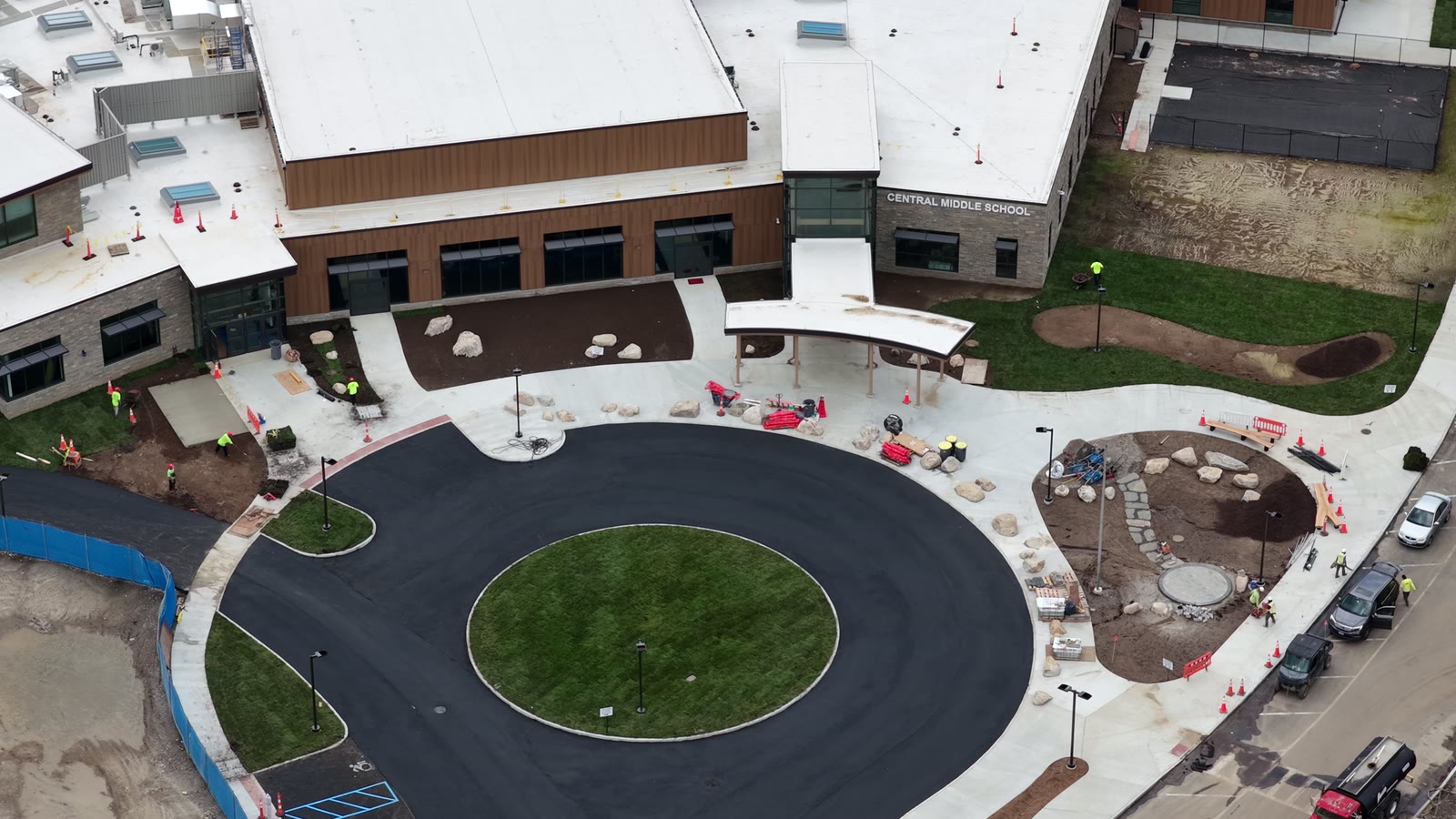 Wide completion aerial showing finished sod around the Central Middle School entrance, main circle, and adjacent building frontage
