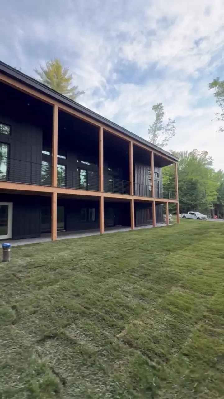 Along the side of the modern home.
