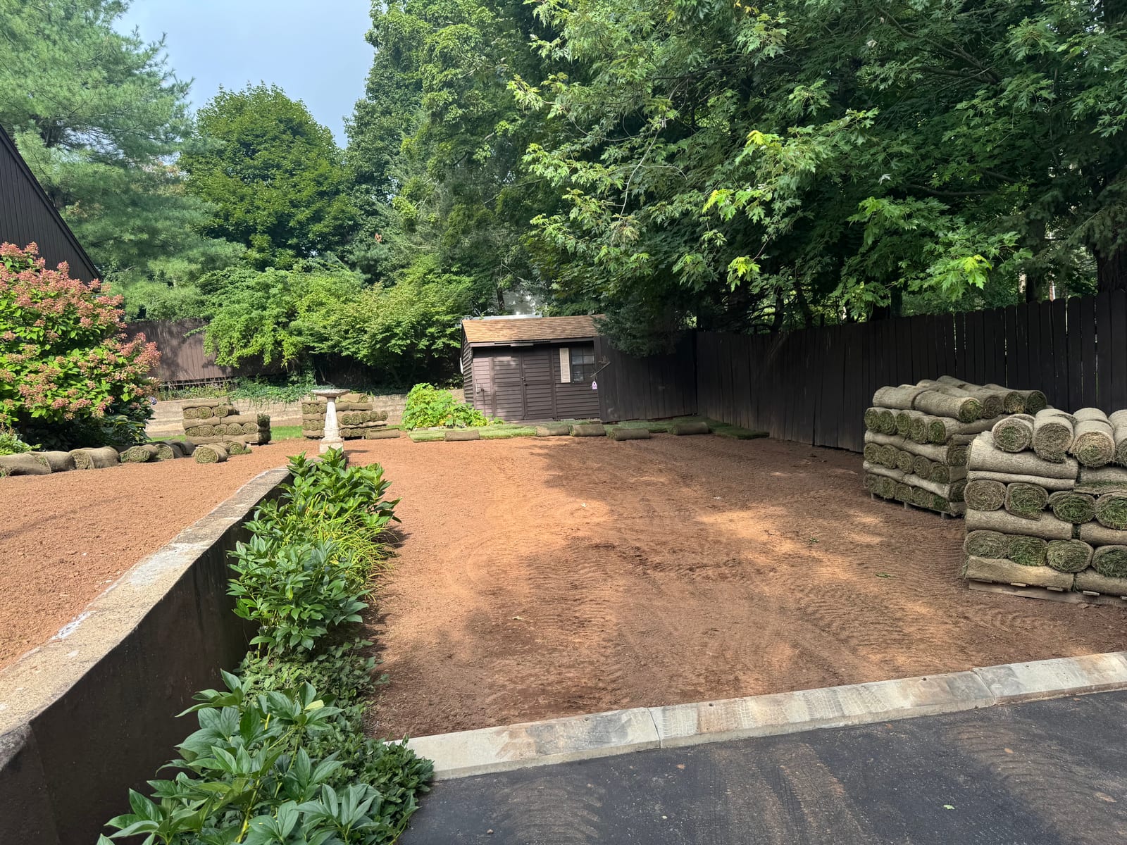 Farm-cut sod pallets staged across the lower yard on install day at the 3,600 sq ft Meriden, CT lawn reset — a real CT Sod job