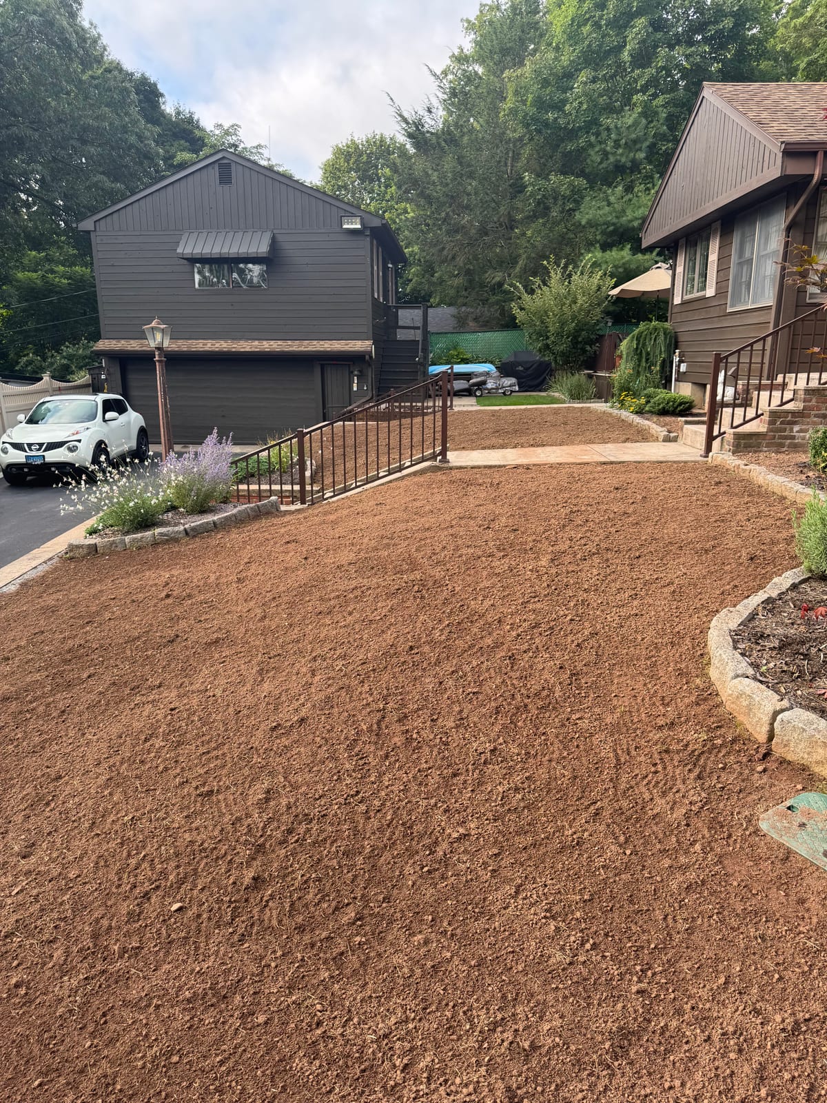 Upper section of a Meriden, Connecticut yard graded smooth beside the parking area and front steps before sod installation
