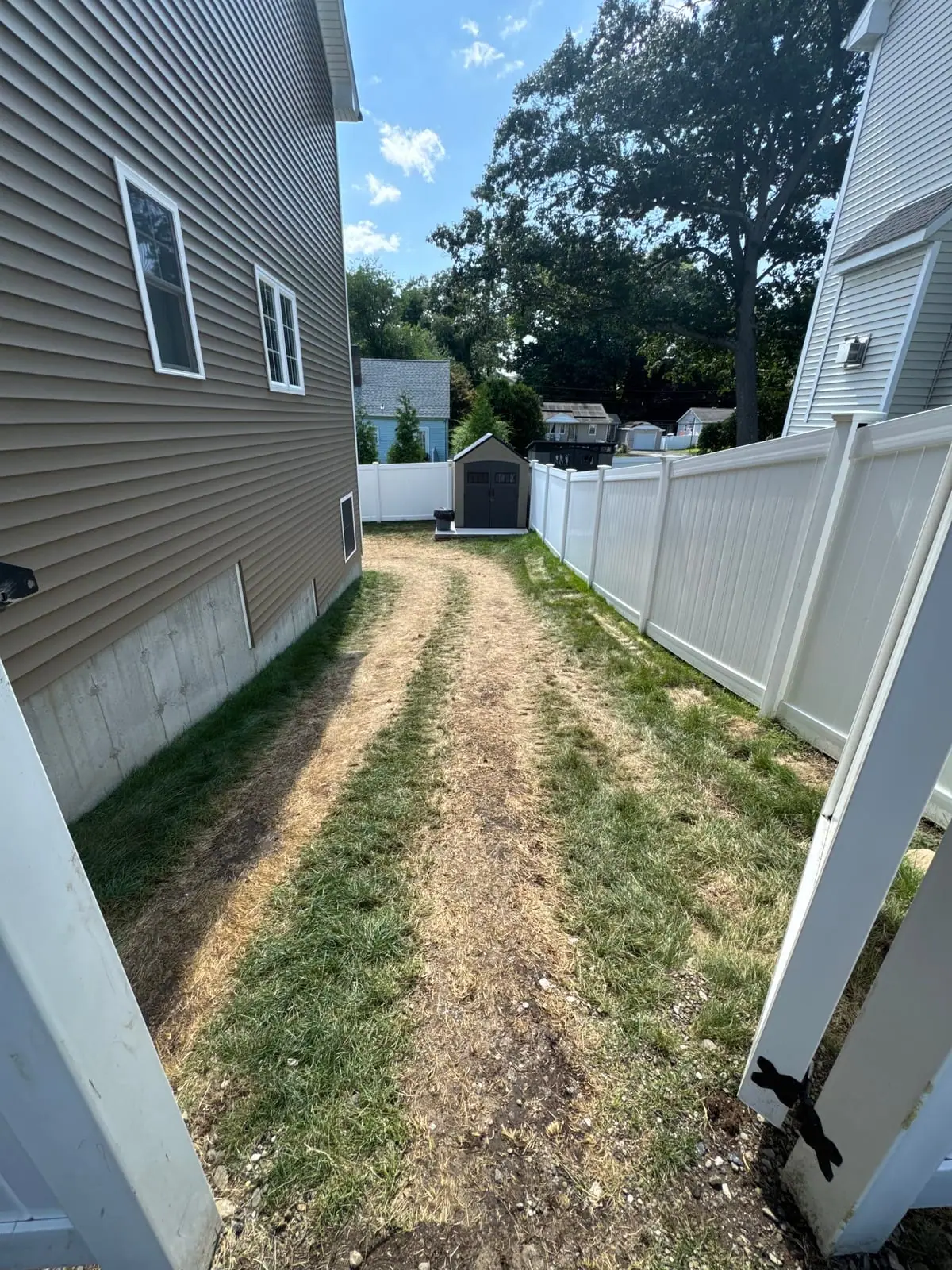 Dead equipment path along the side yard of a Milford, CT home where machines traveled during a patio build