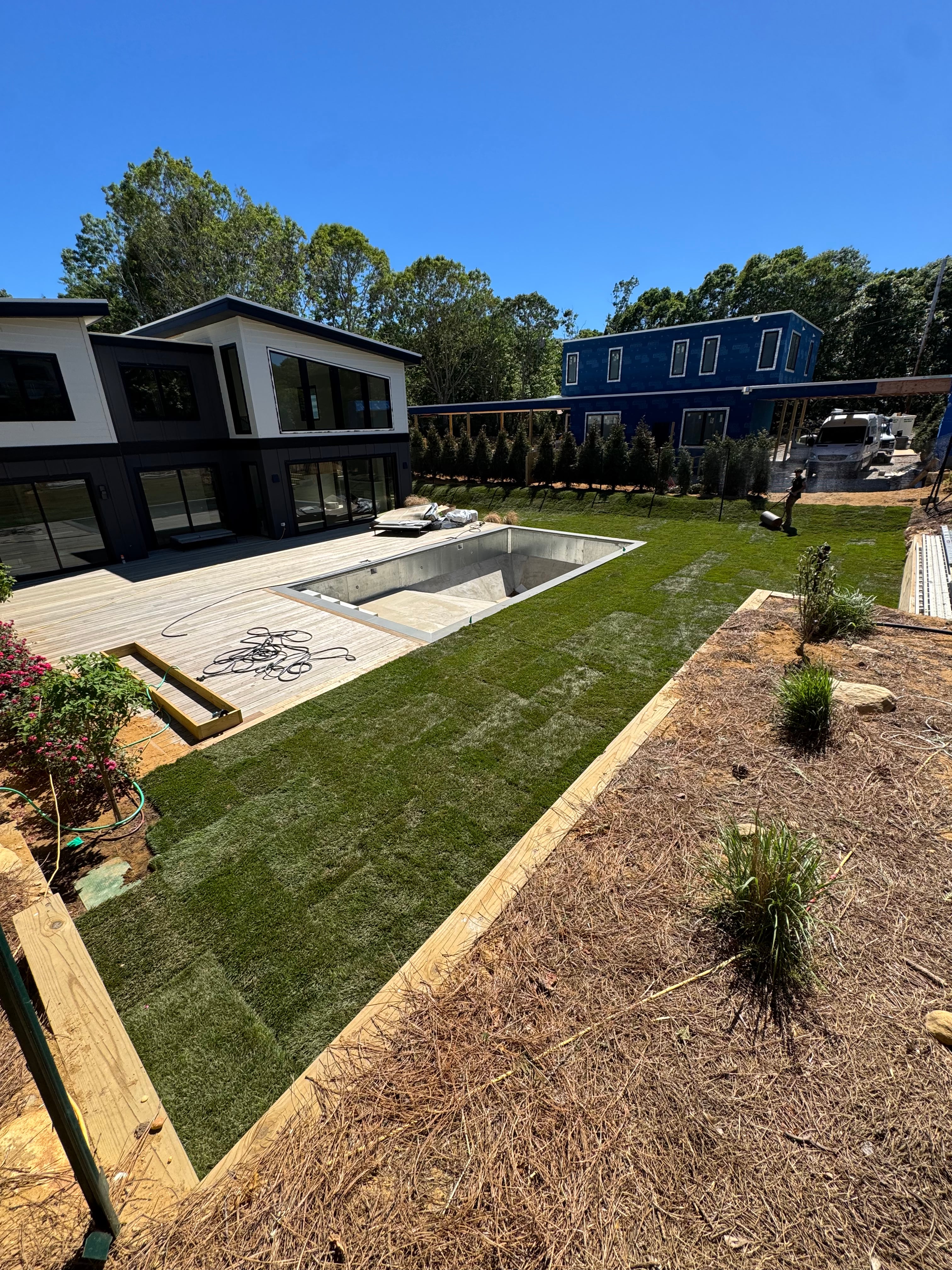 Finished sod installation in Montauk, NY — a lush green lawn wrapping a modern pool and home after CT Sod's install