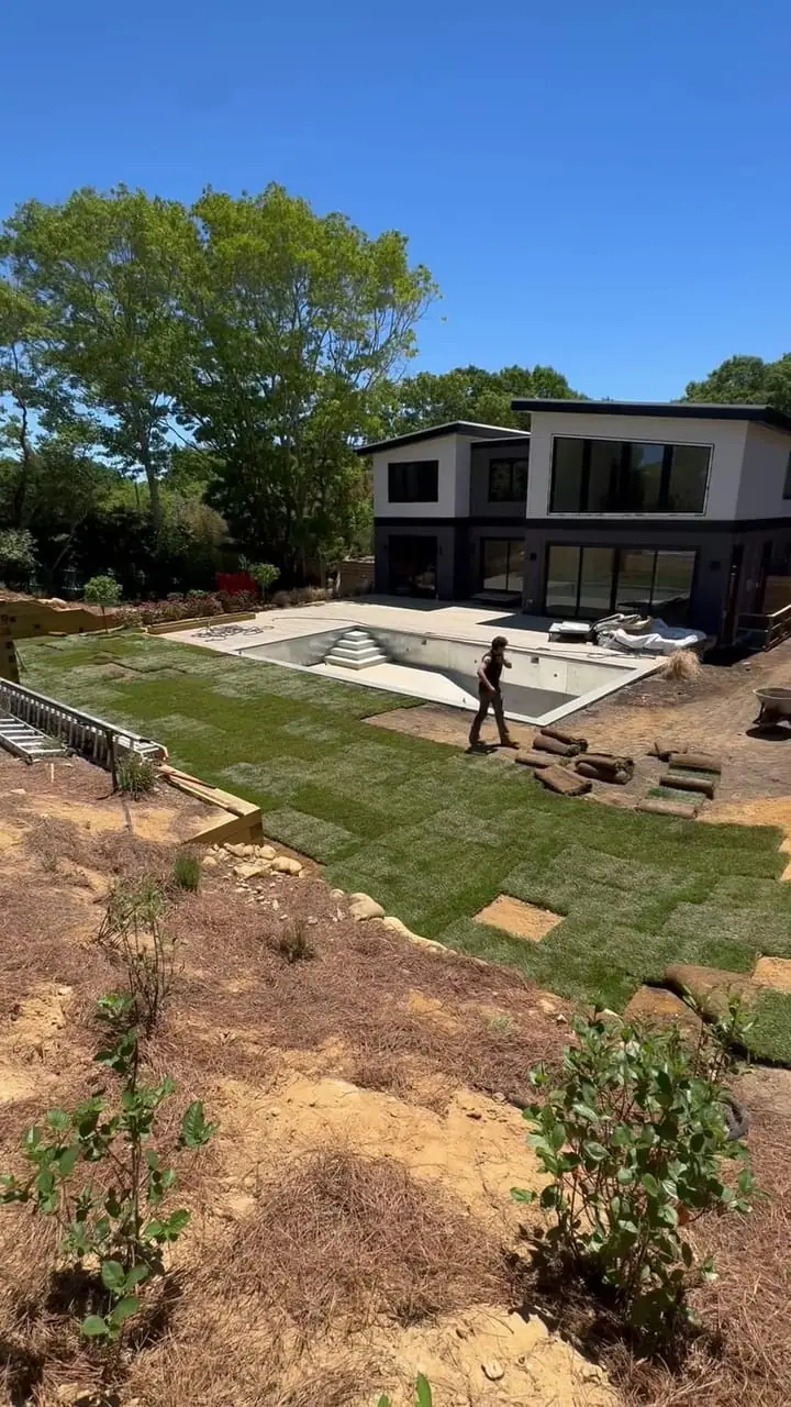 Fresh-cut sod going down around the pool during the 3,000 sq ft Montauk, NY install