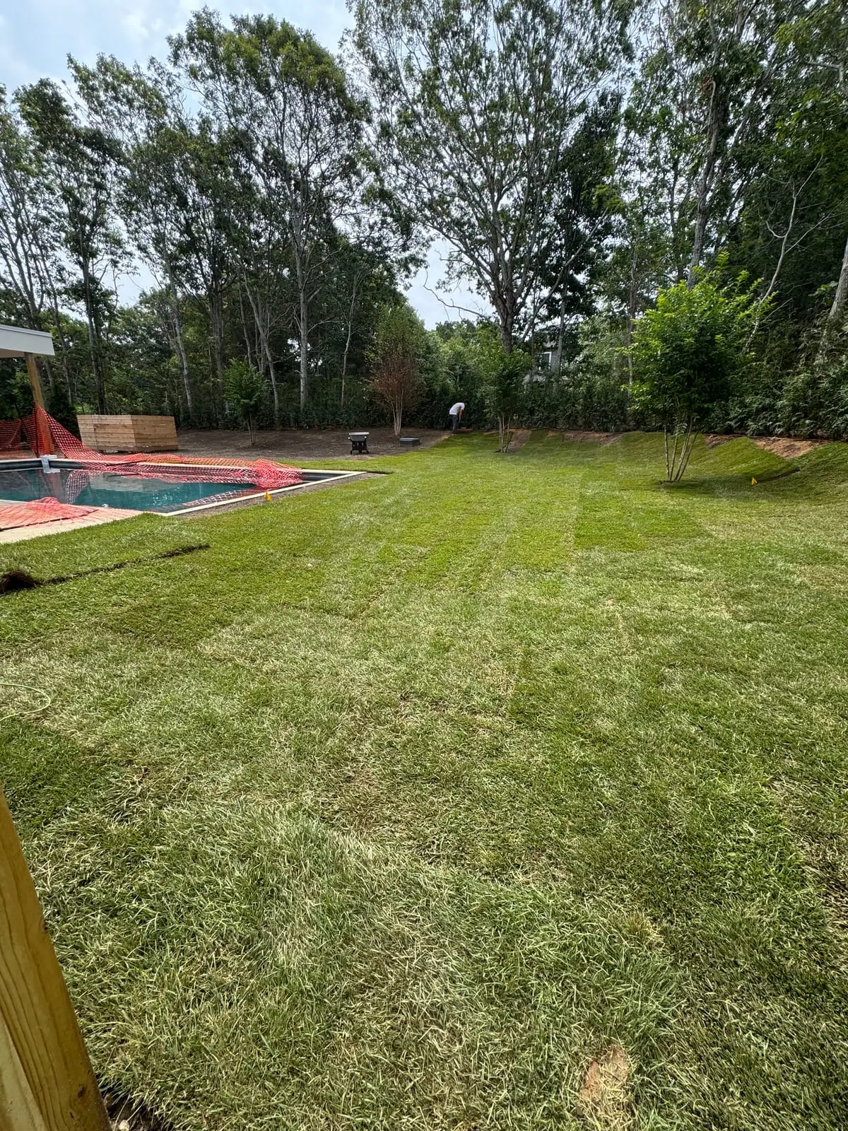 Freshly installed sod lawn surrounding the pool at the 4,500 sq ft new-build home in Montauk, NY