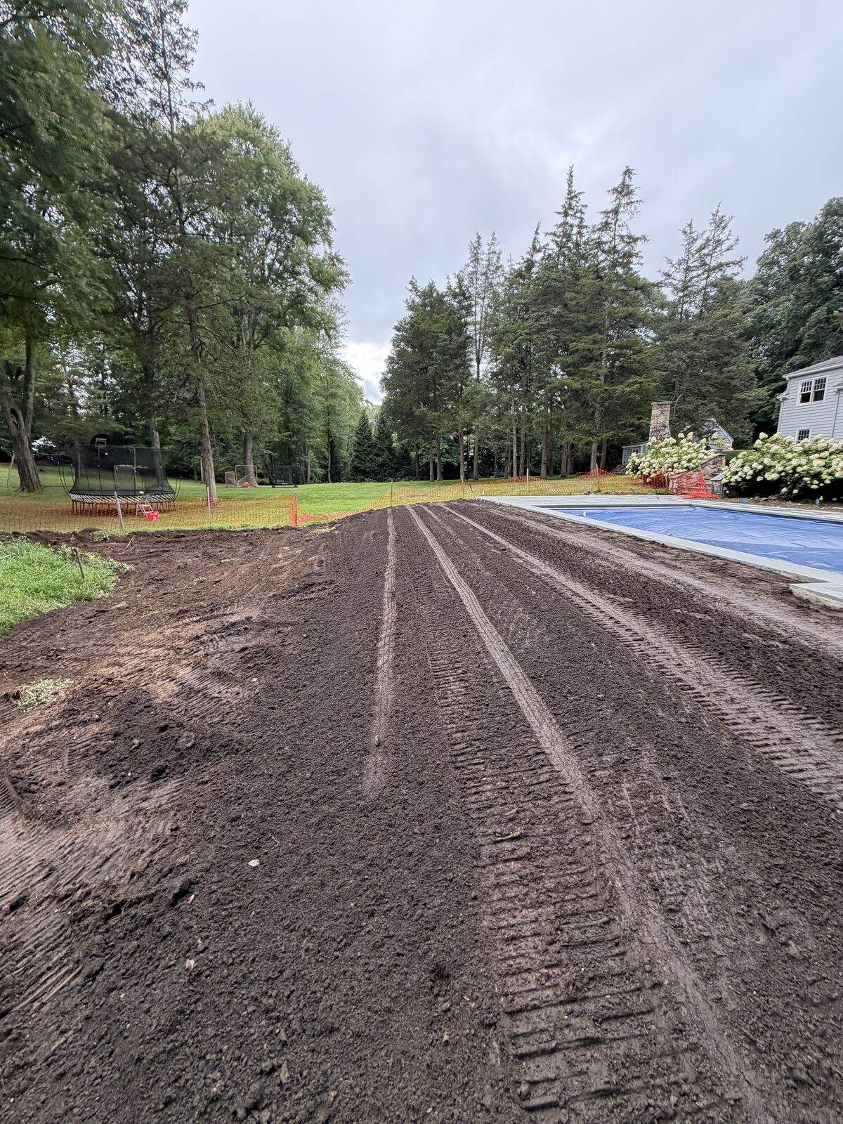 Prepared soil grade beside the covered pool at the New Canaan, CT sod-installation project on Saturday evening