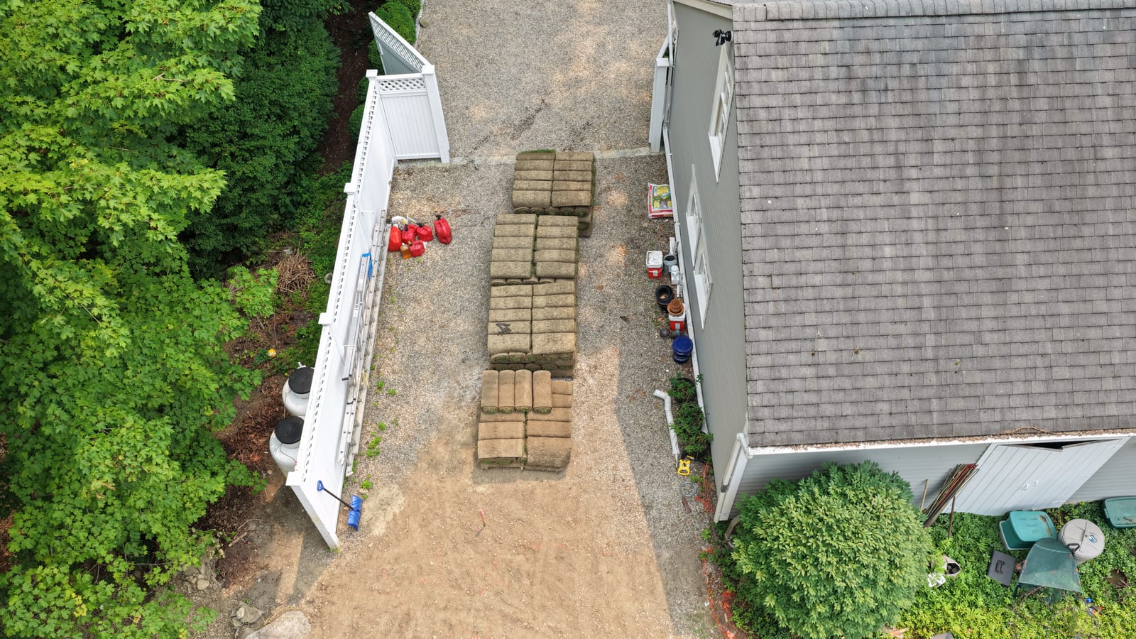 Fresh-cut sod pallets staged in a gravel driveway for a New Canaan, CT delivery