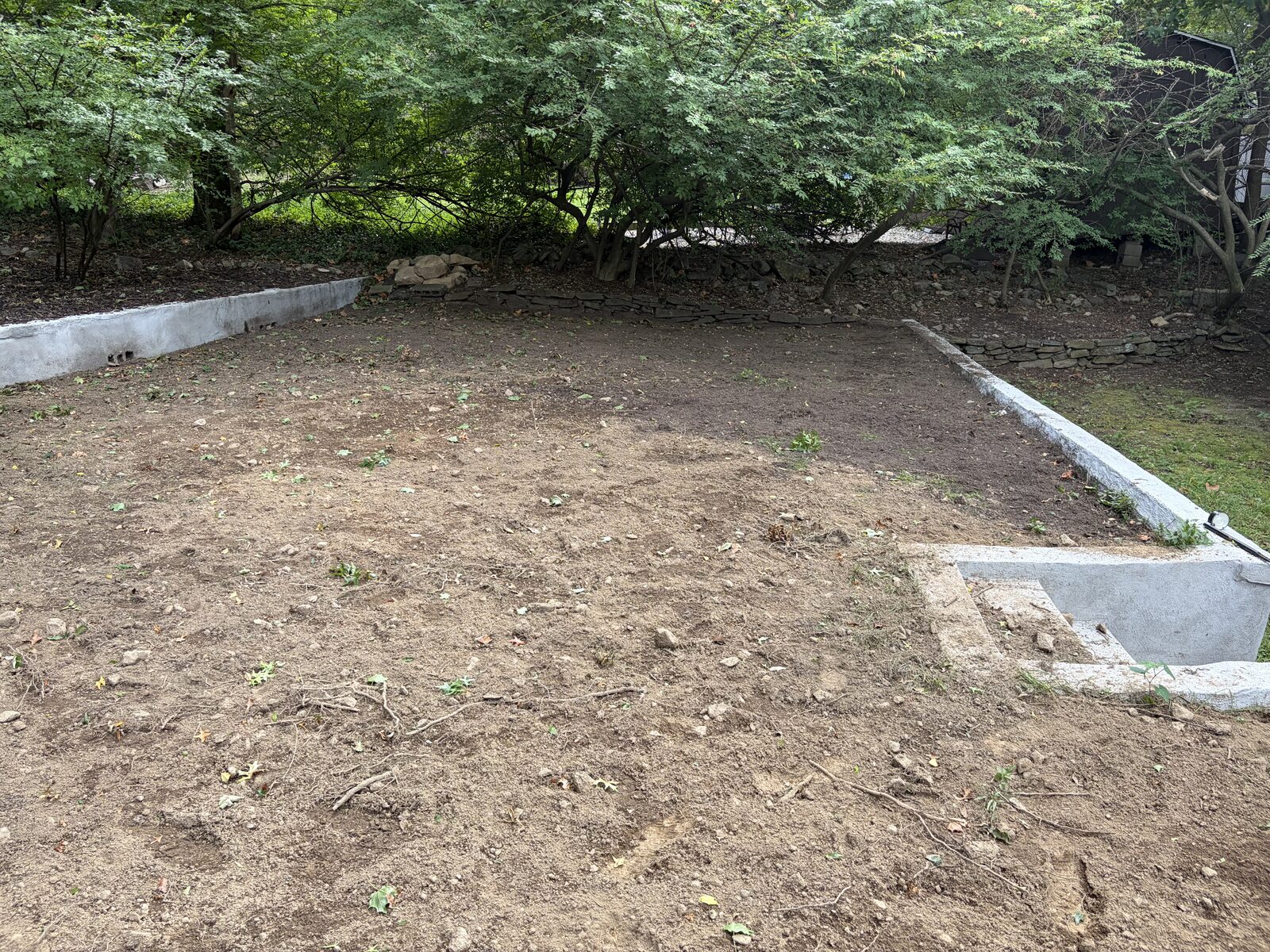 Customer-prepared bare upper lawn between retaining walls before CT Sod installed sod in Norwalk, CT