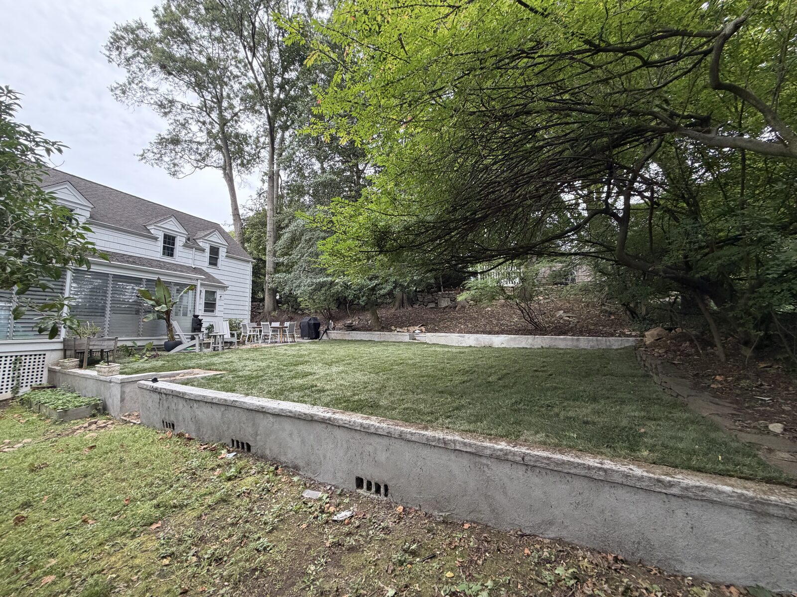 New sod covering the raised lawn beside retaining walls at a Norwalk, CT installation