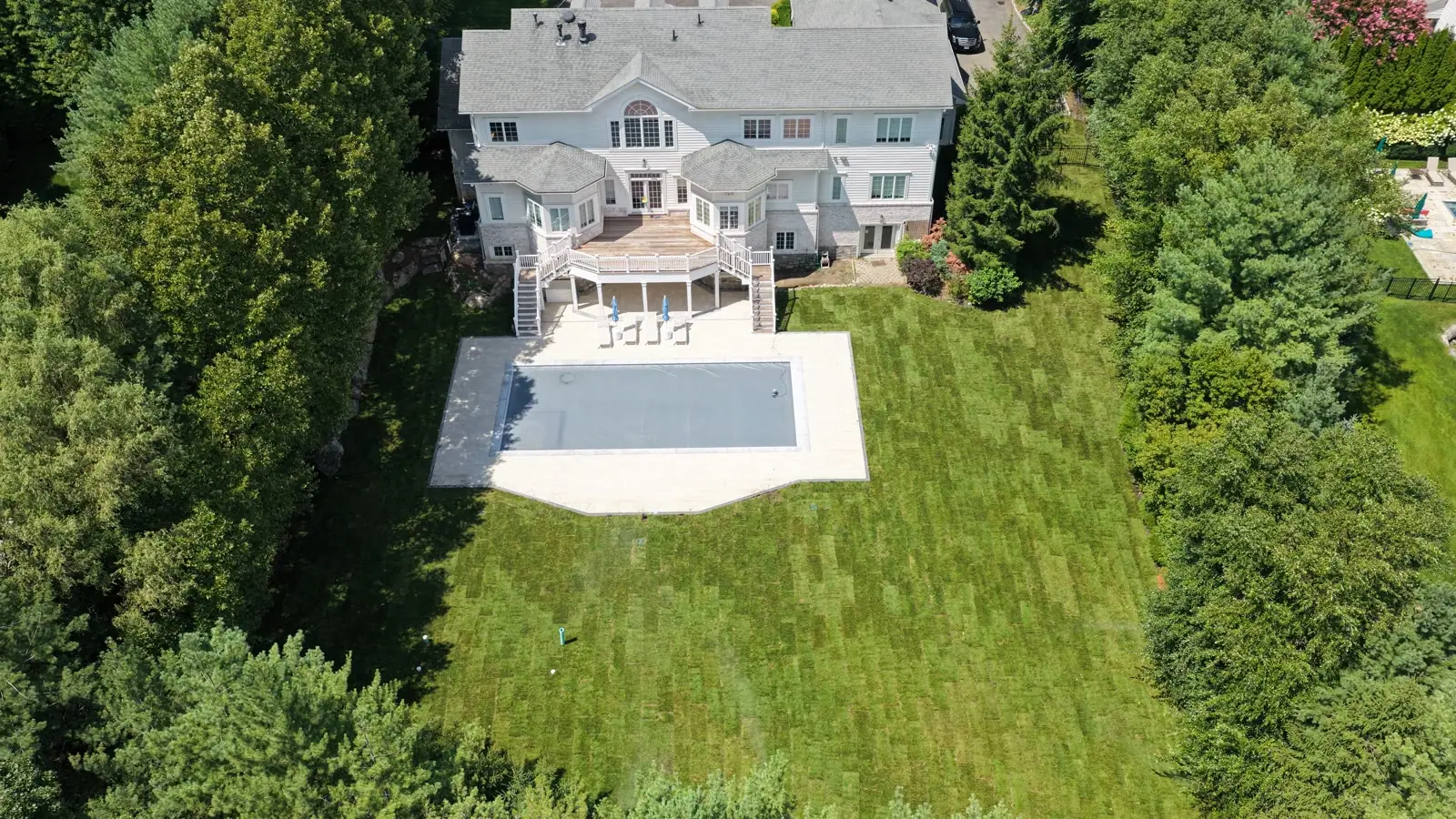 Finished Kentucky bluegrass sod lawn surrounding the new pool and patio of a Purchase, NY estate seen from above