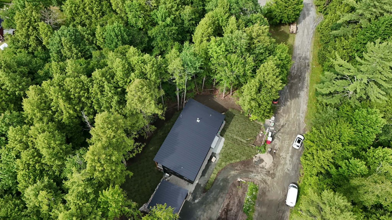 Aerial view of a finished 9,000 sq ft tall fescue sod lawn wrapping a modern home in Quechee, VT