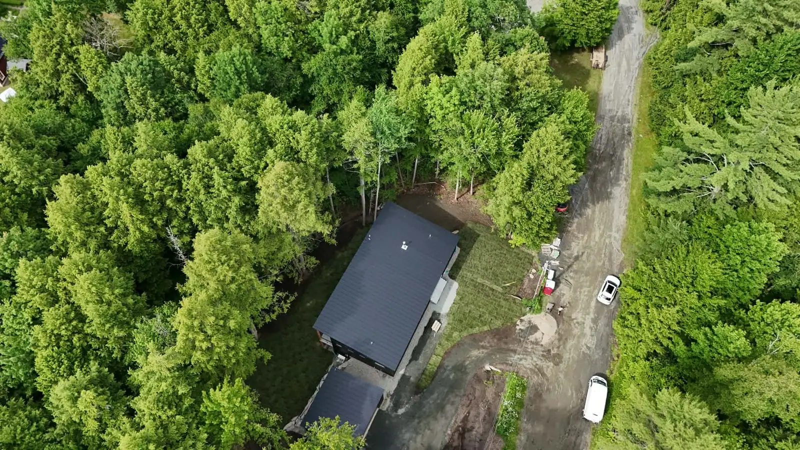 Aerial view of the finished 9,000 sq ft tall fescue sod lawn surrounding the modern home in Hartford, VT (Quechee)