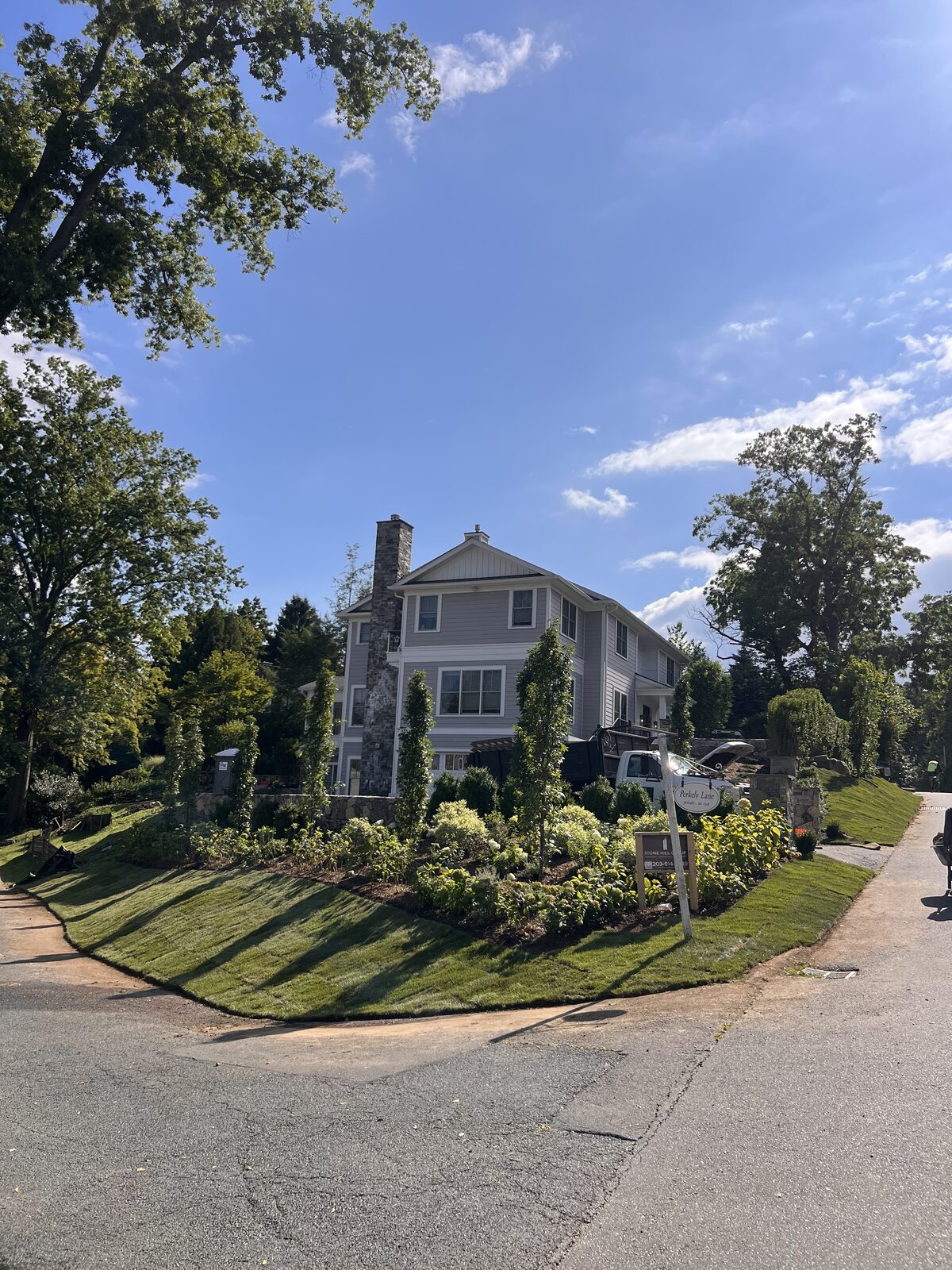New Kentucky bluegrass lawn and fresh plantings at a Riverside, CT corner property after a 3,000 sq ft CT Sod delivery, seen from the street