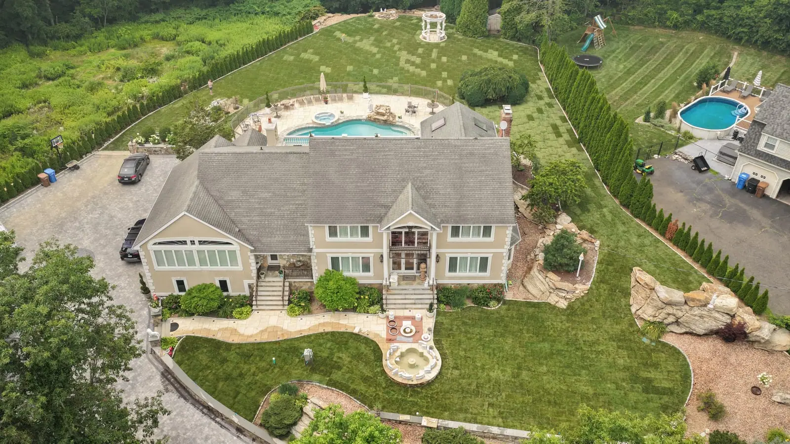 High aerial of the Shelton, CT home after the 17,000 square foot sod installation — roof, driveway, pool, and fresh lawn wrapping the entire property