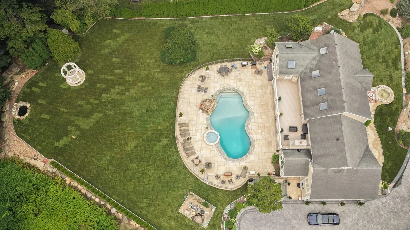 Straight-down drone view of the Shelton, CT backyard after the sod installation — pool, spa, and patio surrounded by fresh sod running from the fence line to the gazebo
