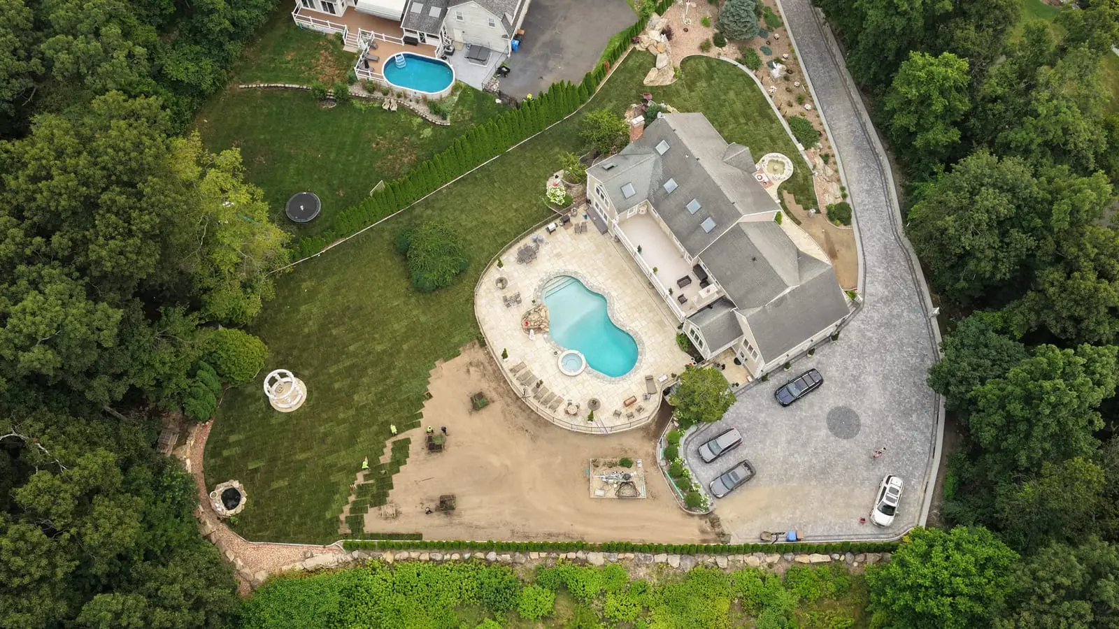 Aerial view of the Shelton, CT property on install day — the house, new pool, and stone patio with fresh sod covering most of the 17,000 square foot yard