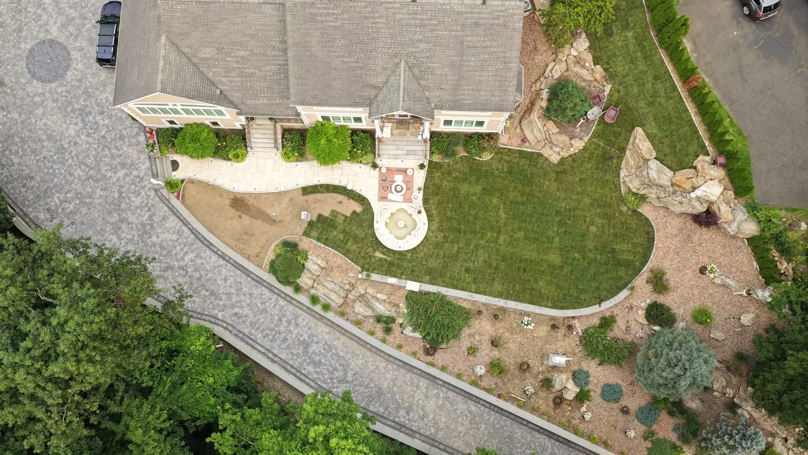 Finished fresh-sod front lawn wrapping the stone walkway and fountain courtyard of the Shelton, CT home, seen from directly above