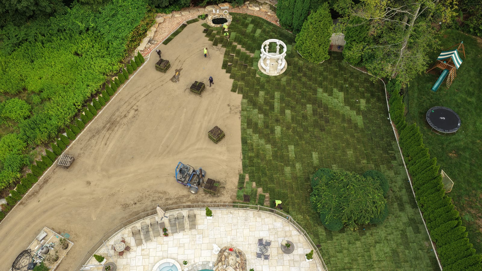 Crew laying fresh-cut sod rolls beside a gazebo on a 17,000 sq ft install in Shelton, CT