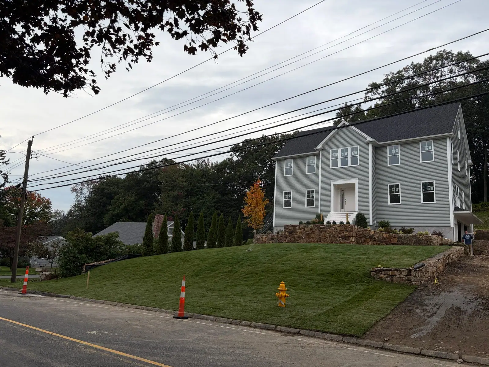 Kentucky bluegrass front lawn below a gray new-construction home in Trumbull, CT