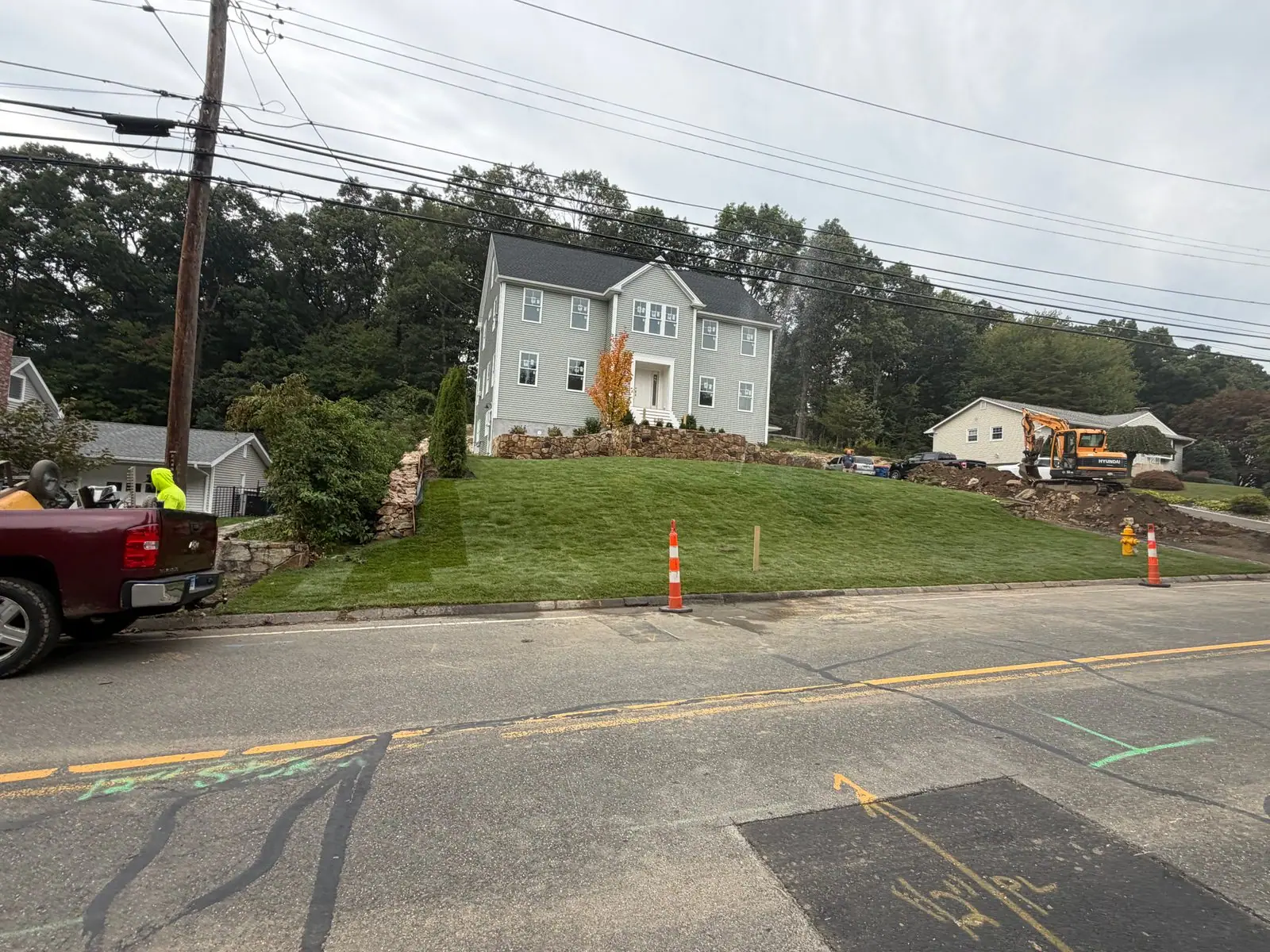 New sod beside stone walls on the Trumbull home's sloping front lawn