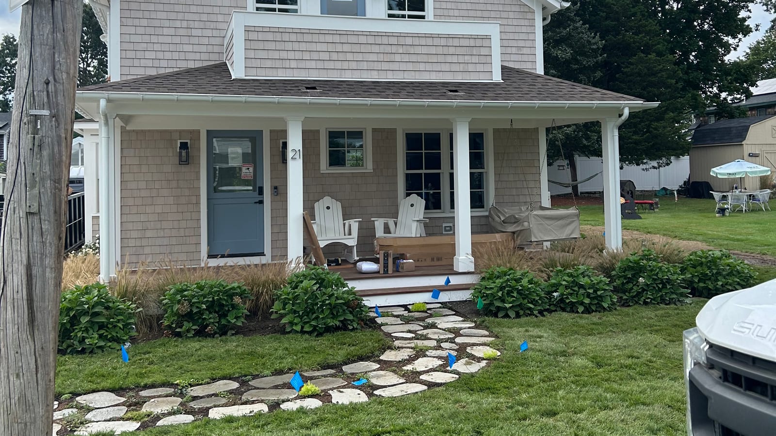 Finished sod installation at a Warren, RI village home — fresh-cut sod and a stone stepper path in front of the shingled porch — a real CT Sod job