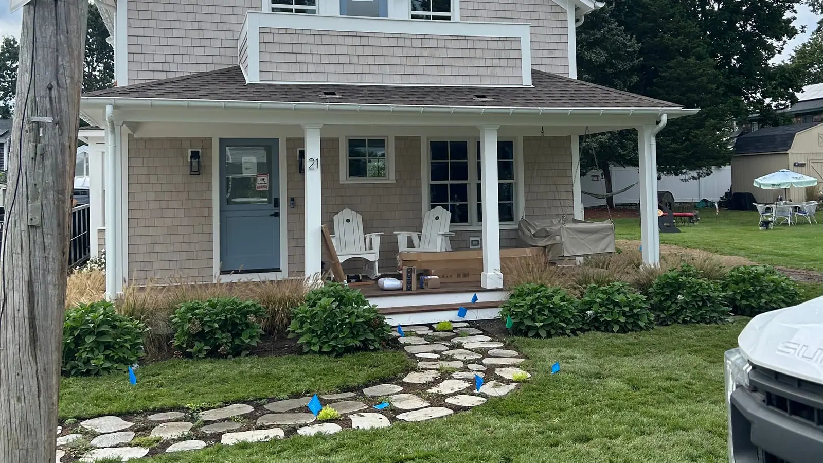 Finished sod installation at a Warren, RI village home — fresh-cut sod and a stone stepper path in front of the shingled porch