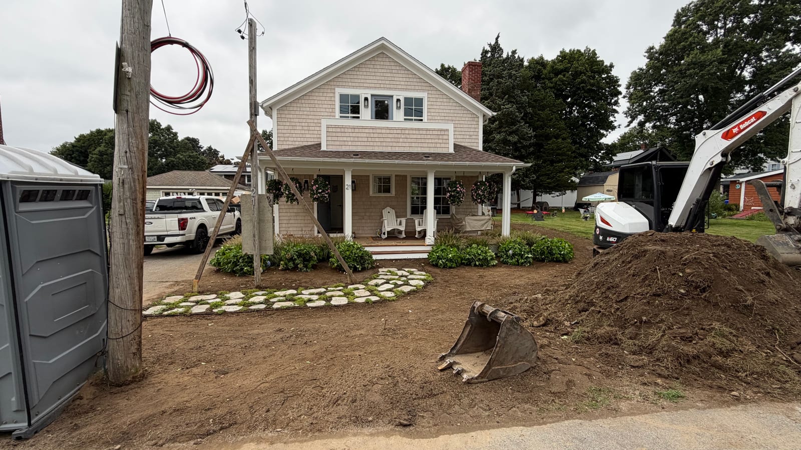 Front yard stripped and graded around a stone stepper path and established beds at a Warren, RI home, prepped for new sod