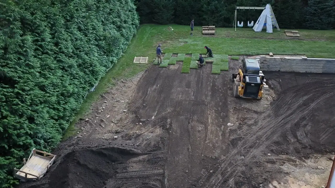 5:10 p.m. Friday — back over the yard: green spreading in from the edges while the last of the machine work wraps up