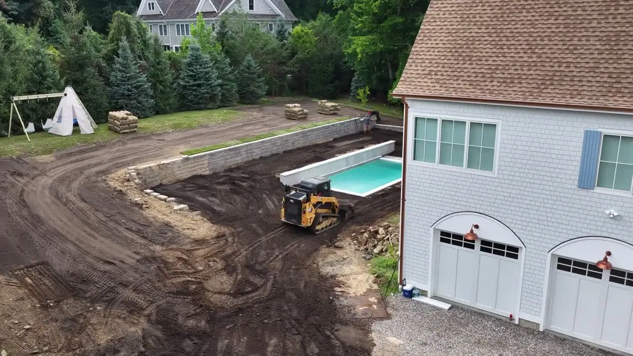3:56 p.m. Friday — a full lap over the Westport yard: screened topsoil graded around the new pool, rescued sod staged on pallets, and the first rows already on the ground