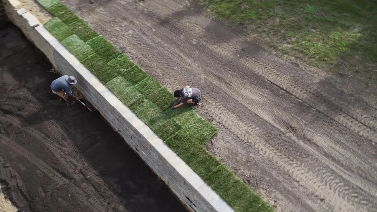 4:05 p.m. — the first green courses run the fence line while the crew squares up the next pallets