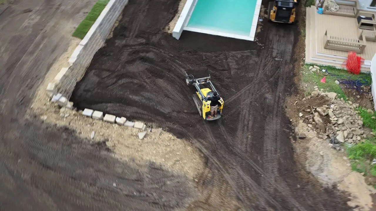 Sweeping from the garage side across the graded yard to the pool wall, then up and over the trees