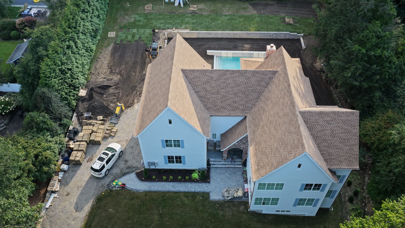 Evening aerial of the Westport property with fresh sod rows down across the lawn after the one-day installation push