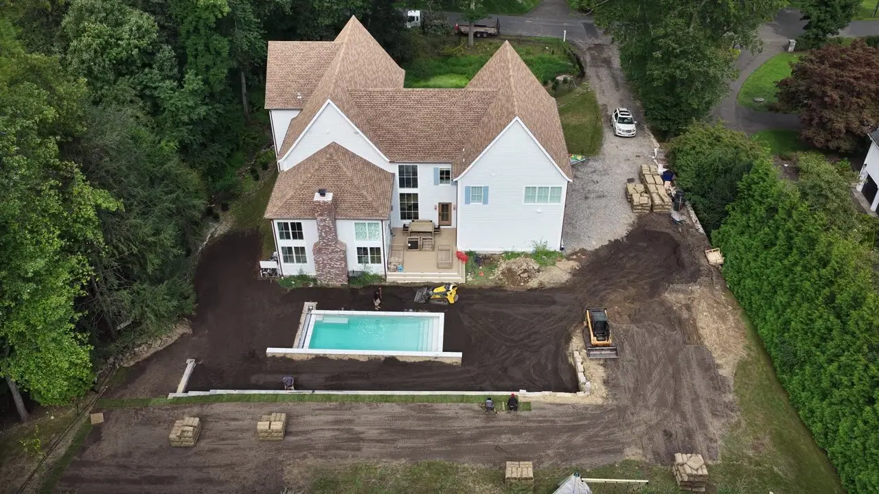 High and wide over the house and pool — every zone graded, edged, and waiting on the first pallets