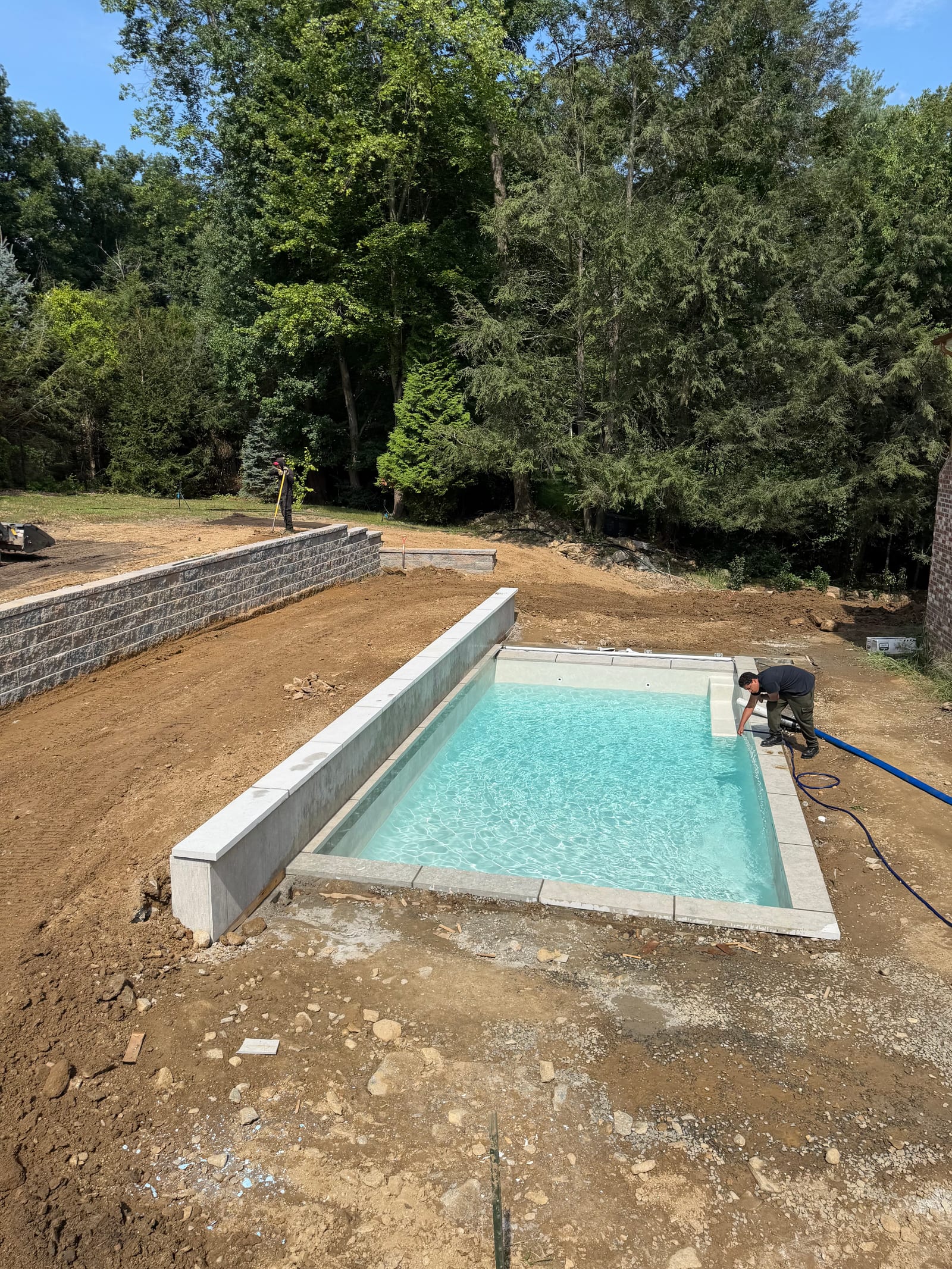 Rough grade and new pool wall during late-morning site preparation for the Westport sod installation