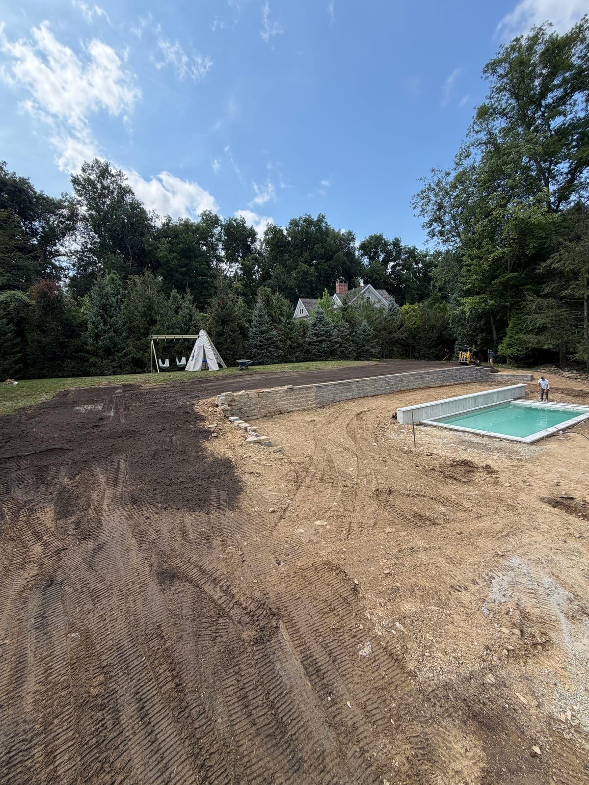 Dark screened topsoil spread across the upper lawn above the separate pool construction on Friday afternoon in Westport