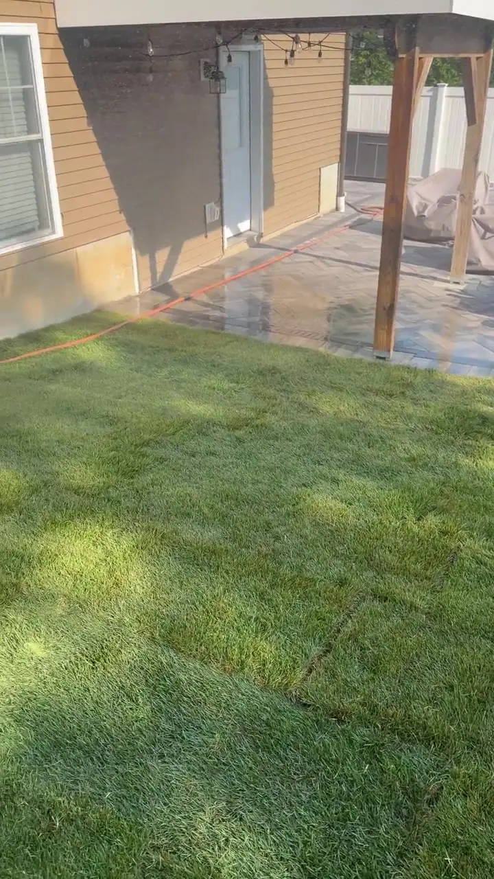 Pan from the fence-line side run of fresh Kentucky bluegrass up to the brand-new paver patio in Milford, CT