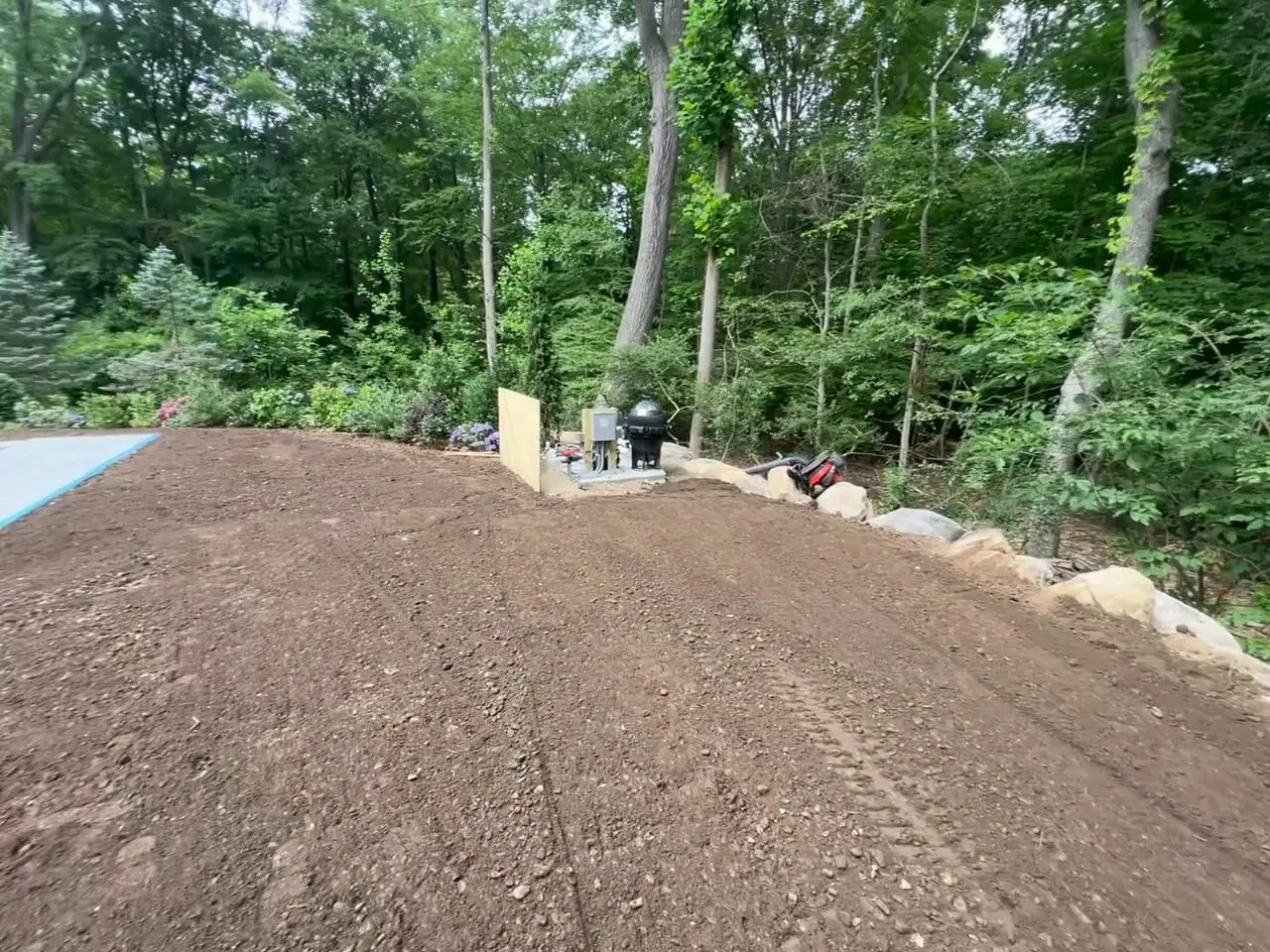 Walkthrough of the finished sod-ready grade around a new covered pool in New Canaan, CT — topsoil raked smooth and pitched away from the coping