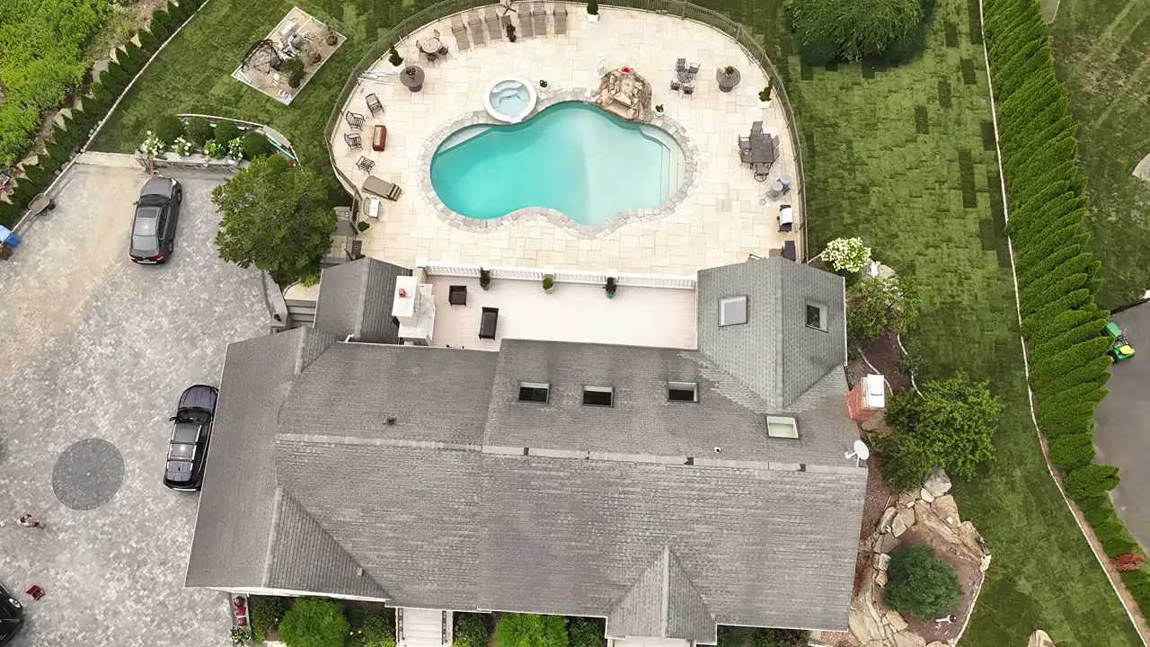 Aerial orbit of the Shelton, CT home after the sod install — fresh sod wrapping the fountain courtyard, side yards, and pool yard