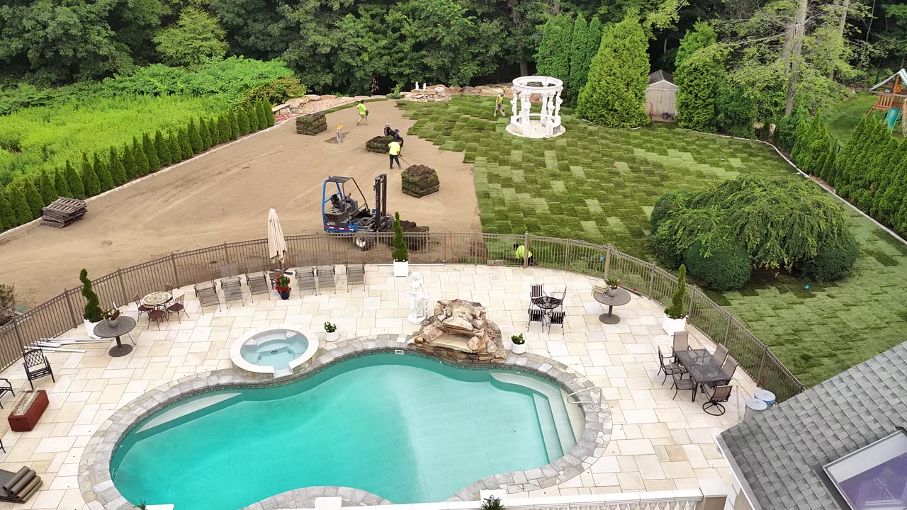 The crew and all-terrain forklift working the seam above the pool patio, rolls going down pass by pass