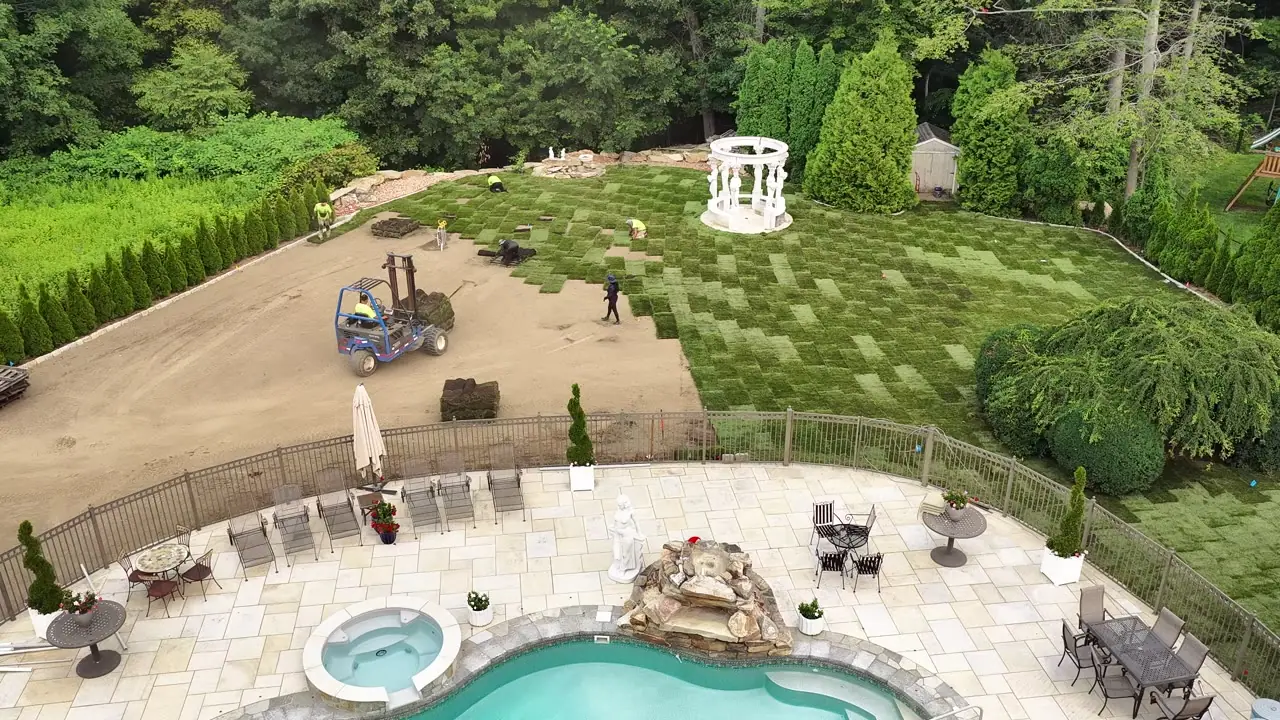Drone view over the new pool and spa in Shelton, CT as fresh sod sweeps across the back yard toward the tree line