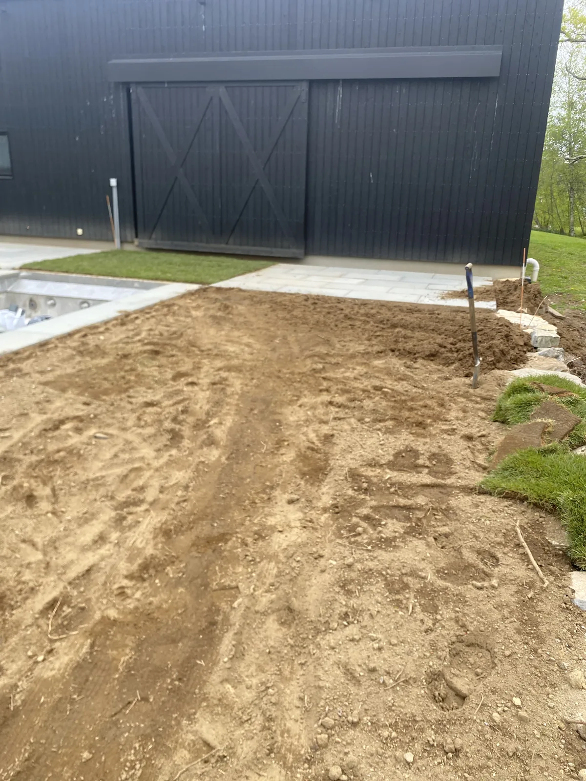 Warren CT sod install prep — graded approach to a black barn-style estate house in the Litchfield Hills