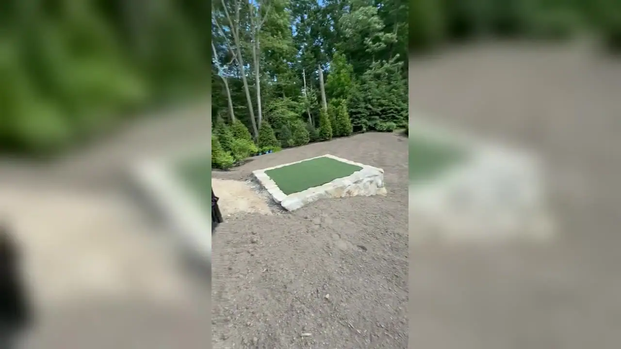 Final sod prep in the backyard of a New Canaan, CT estate — grading around the pool and putting green before fresh-cut sod is laid