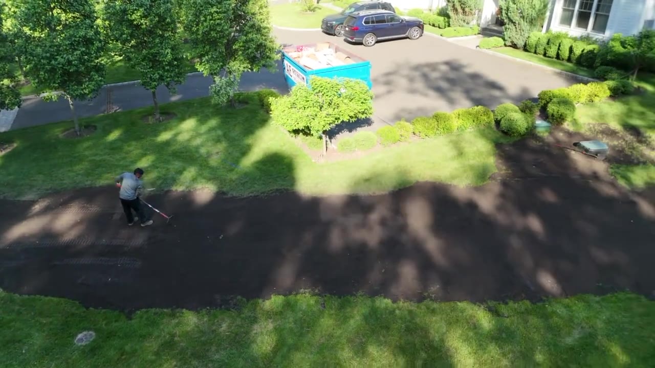 Drone fly-over of the front yard of a New Canaan, CT estate finishing sod prep after spreading 220 yards of fresh topsoil, with the driveway and freshly raked grade in view